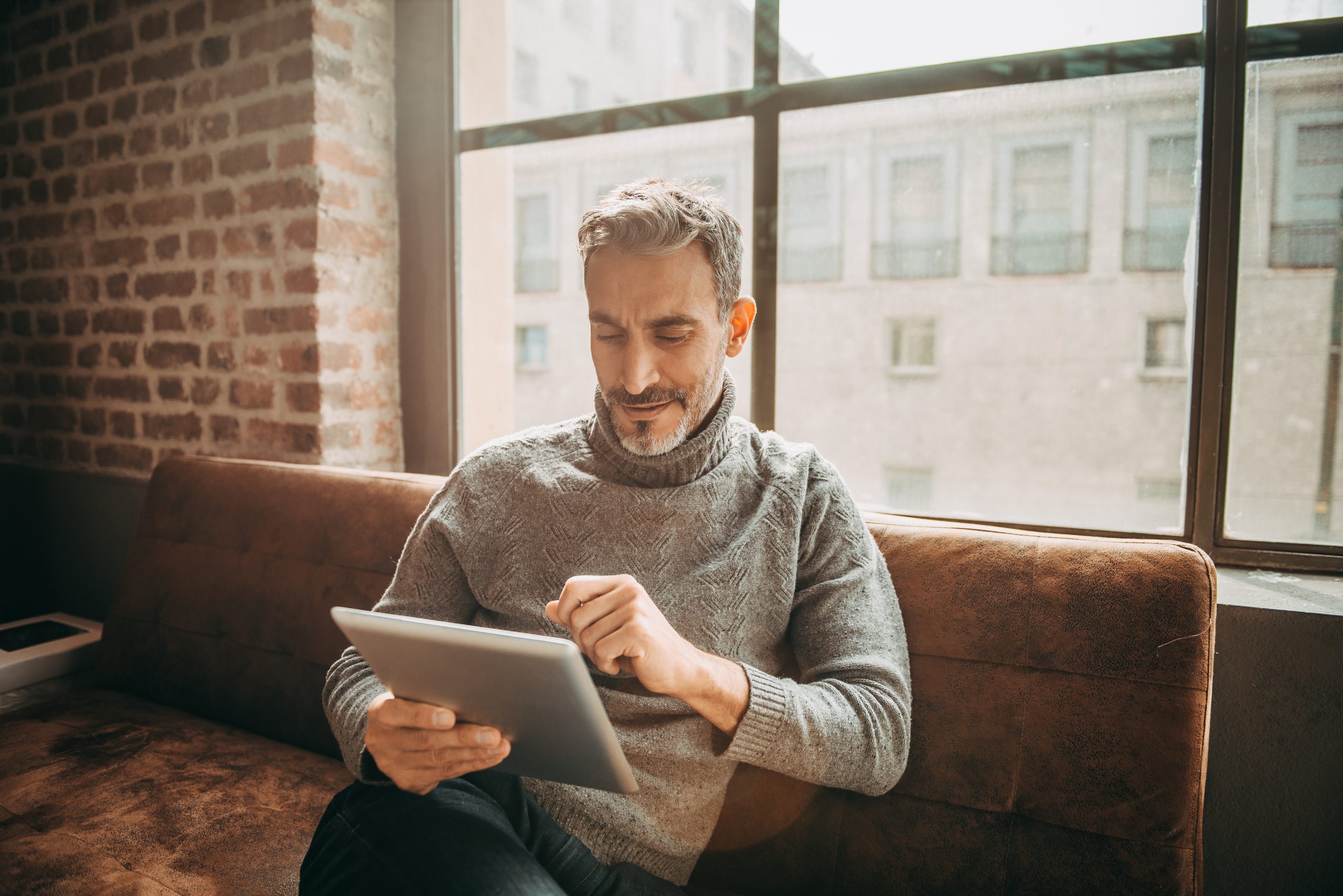 Man reading on a tablet and smiling
