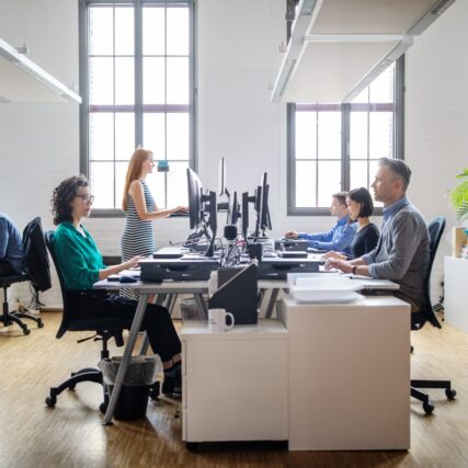 Business people at their desks in a busy, open plan office. Startup business people working at a modern office.